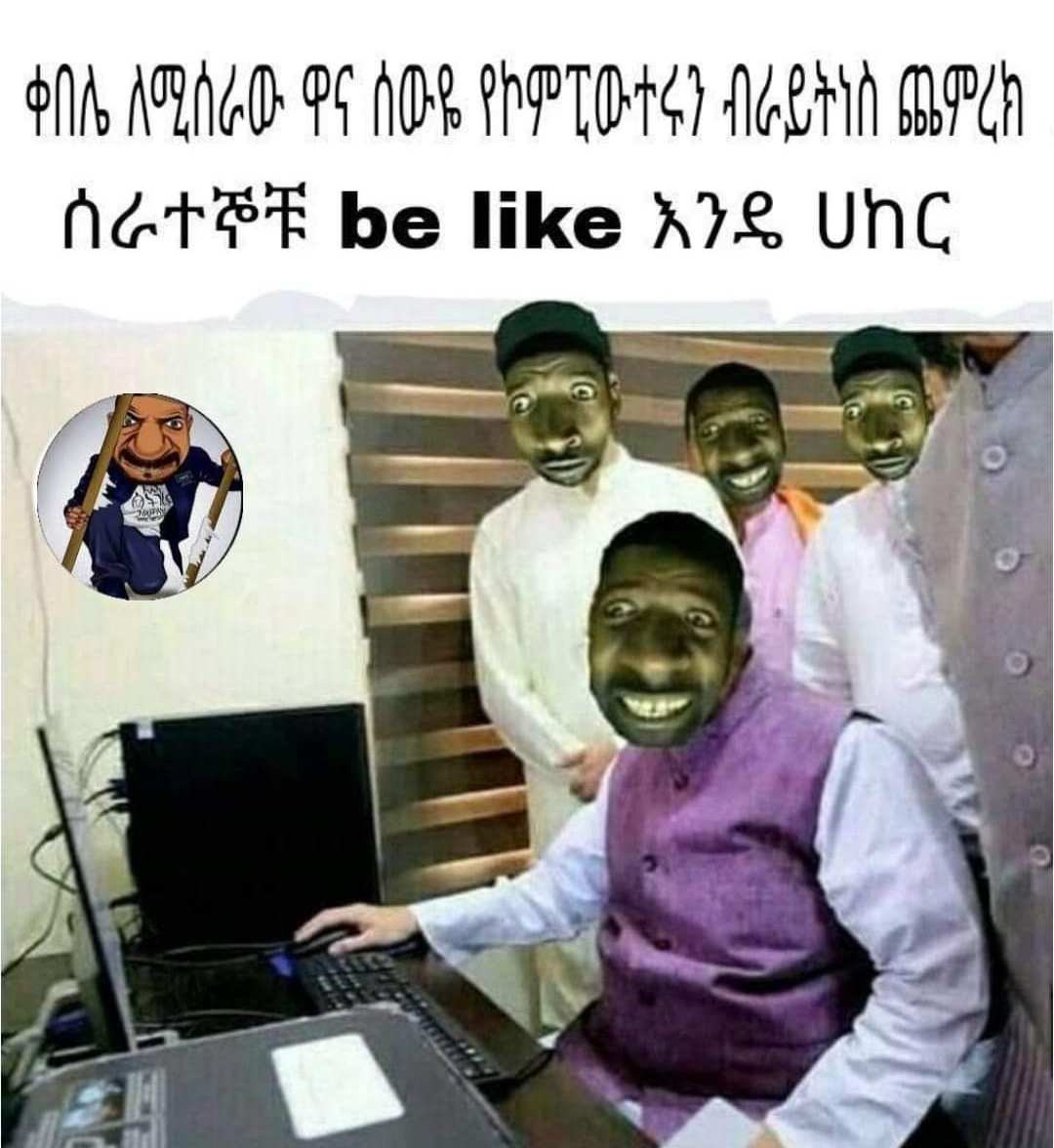 a man in a purple shirt is sitting at a computer